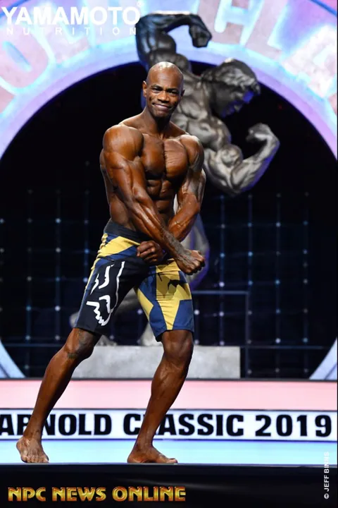 Antony Bessala in a side chest pose on the Arnold Classic 2019 stage