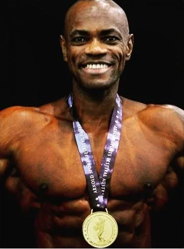 Antony Bessala smiling with the Arnold Sports Festival Australia medal