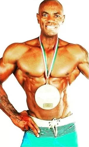 Antony Bessala wearing an Olympia Amateur medal on a white background