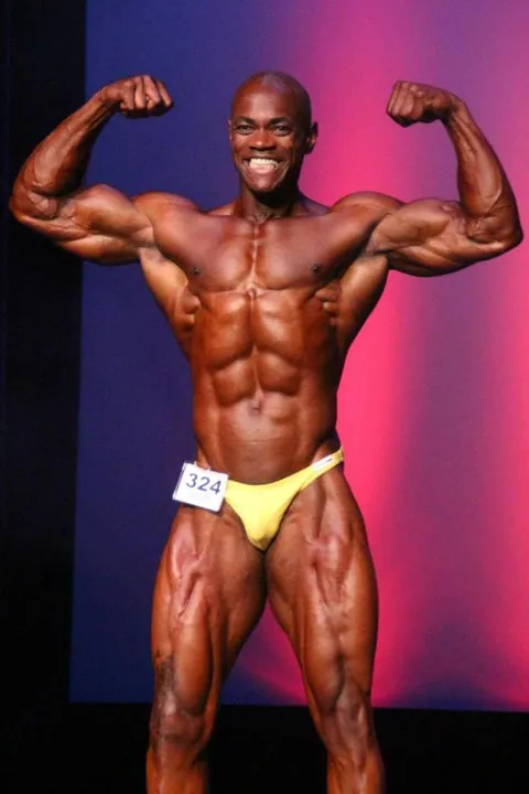 Antony Bessala on the Musclemania Pro stage: front double biceps, number 324