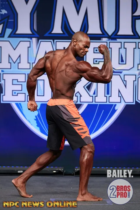 Antony Bessala in a side biceps pose at Olympia Amateur United Kingdom