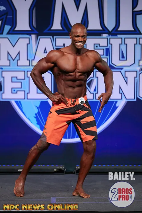 Antony Bessala in orange and black shorts at Olympia Amateur United Kingdom