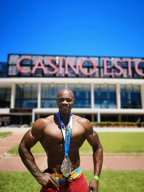 Antony Bessala wearing a medal outdoors in front of Casino Estoril in Portugal