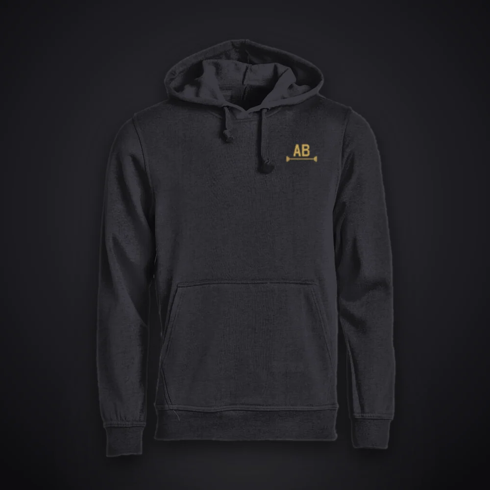 Champion Edition hoodie in iron black, front: AB barbell mark in gold on the left chest