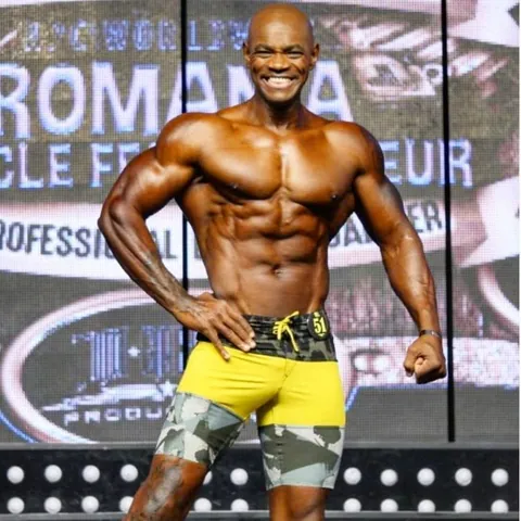 Antony Bessala smiling in yellow shorts at Romania Muscle Fest Pro